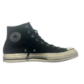 Black high-top sneaker with white sole on a gray background