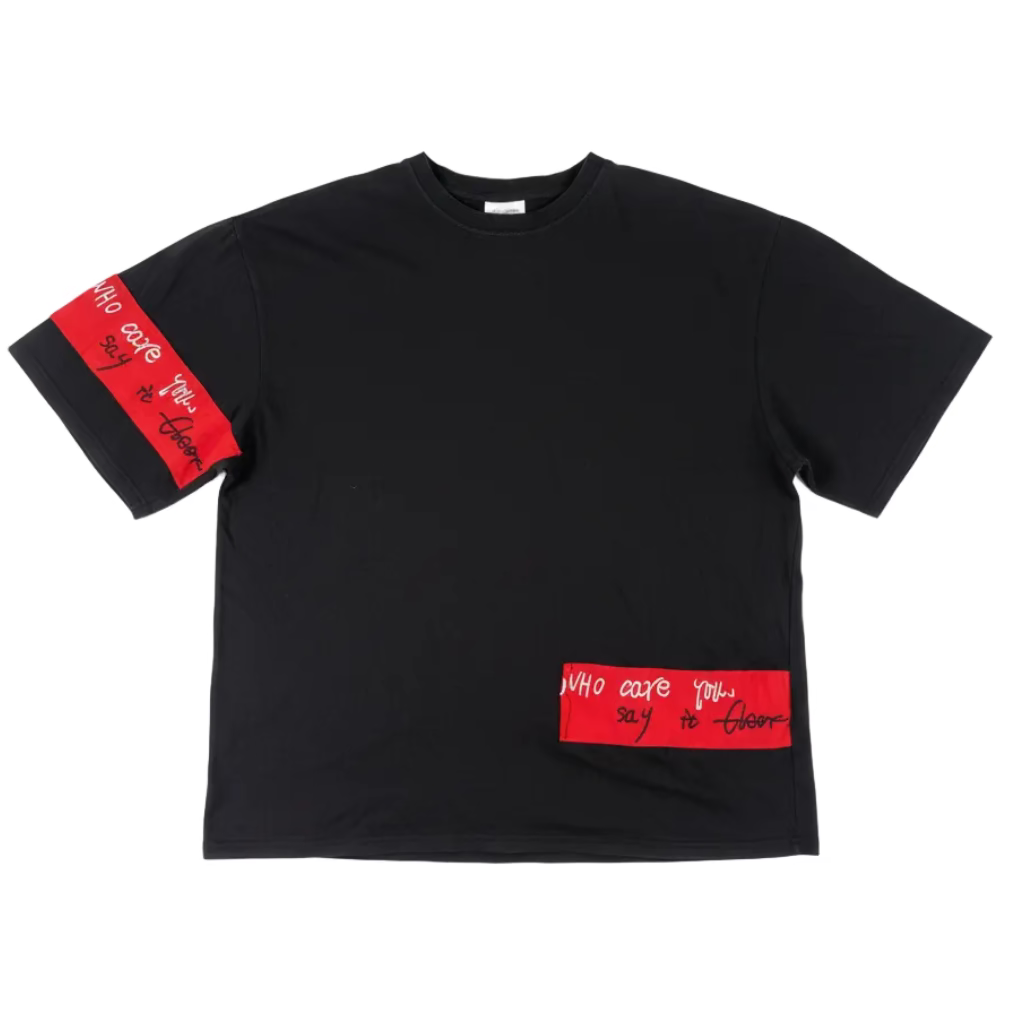 Black t-shirt with red patches on a white surface